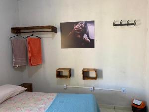 a bedroom with a bed and a picture on the wall at COMPARTILHADO Do TERRÃO in Três Marias