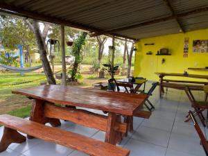 a group of wooden benches in a room with a hammock at COMPARTILHADO Do TERRÃO in Três Marias
