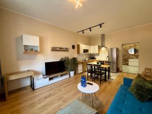 a living room with a blue couch and a kitchen at Apart Brzeg in Brzeg