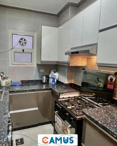 a kitchen with white cabinets and a stove top oven at CAMUS 343, Princess Resort in Hurghada