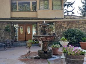 a fountain in front of a house with potted plants at Rae Leigh Heights BnB in Saanichton