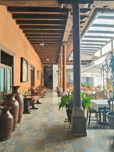 a hallway with tables and chairs and plants in a building at HOTEL MI SOLAR EJECUTIVO in Uruapan del Progreso