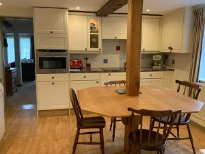 a kitchen with a wooden table with chairs and a tableasteryasteryasteryasteryastery at The Old Stores in Bury Saint Edmunds