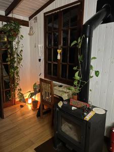 a living room with a wood stove and a chair at Cabaña La Colmena in Tigre