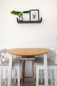 a wooden table with two stools and a shelf at Bright studio Martigny - 30 min from Verbier - free parking in Martigny-Ville