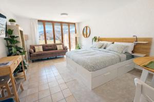 a bedroom with a bed and a living room at Bright studio Martigny - 30 min from Verbier - free parking in Martigny-Ville
