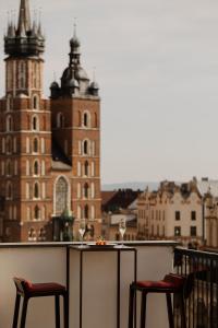 a table and two chairs on a balcony with a view of buildings at Hotel Stary in Krakow
