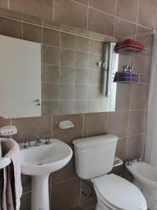 a bathroom with a white toilet and a sink at Depto tranquilo y equipado cerca del mar in Puerto Madryn