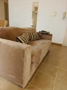 a brown couch sitting in a living room at Depto tranquilo y equipado cerca del mar in Puerto Madryn