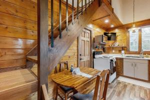 eine Küche mit einem Holztisch und einer Treppe in einer Hütte in der Unterkunft Moose Chalet in Bigfork + 26 Fotos