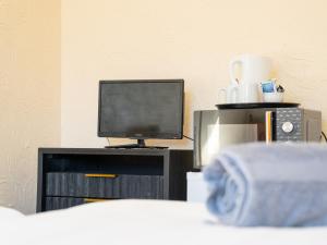 a room with a tv and a bed and a tvictericter at Chestnut Lodge Bed & Go in Eastleigh