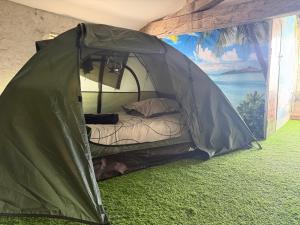 a green tent with a bed inside of it at Les Flots de Barzan Expérience Glamping Insolite in Barzan