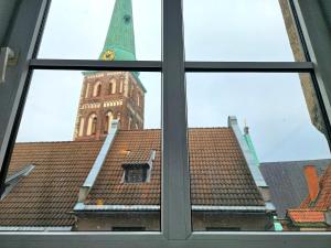 a view of a clock tower from a window at Old Town Cathedral Views - Steps from Dome Square -Friends & Family stay in Riga