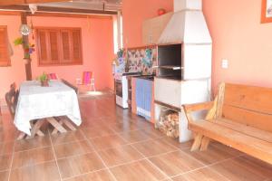 a kitchen with a table and a stove and a table and a bench at Cabanas Sol e Lua in Imbé +7 photos