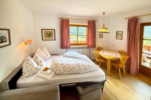 ein kleines Schlafzimmer mit einem Bett und einem Tisch in der Unterkunft Agriturismo Kabishof in Villnöss