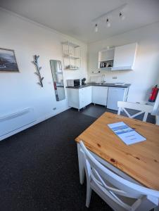 a kitchen and dining room with a wooden table at Sefdalur in Höfn +32 photos