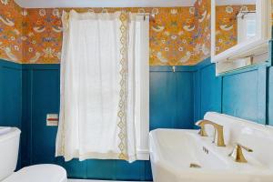 a blue bathroom with a sink and a toilet at The Hilltop - West Wing in Waterbury +24 photos