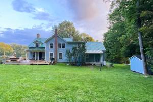 a blue house with a large yard at The Hilltop - West Wing in Waterbury
