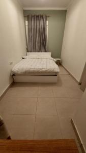 a bed in a small room with a window at Christina Apartment 2 in Drama +1 photo