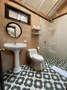 a bathroom with a toilet and a sink and a mirror at Chilcabamba Lodge in Machachi +50 photos
