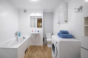 a white bathroom with a washing machine and a sink at Apartament przy Walowej in Łańcut