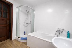 a bathroom with a shower and a tub and a sink at Apartament przy Walowej in Łańcut +14 photos