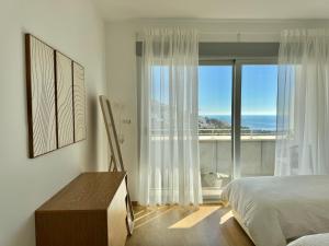 a bedroom with a bed and a view of the ocean at Althaia Hills - Precioso adosado con terraza panorámica al mar y montaña in Altea +38 photos
