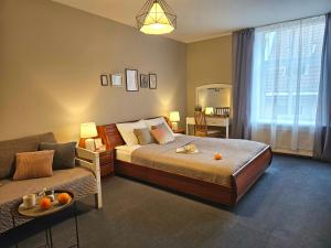 a bedroom with a bed and a couch at Old Town Cathedral Views - Steps from Dome Square -Friends & Family stay in Riga