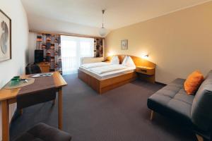 a hotel room with a bed and a couch at B&B Number 1 in Loipersdorf bei Fürstenfeld