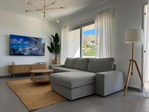 a living room with a couch and a table at Althaia Hills - Precioso adosado con terraza panorámica al mar y montaña in Altea