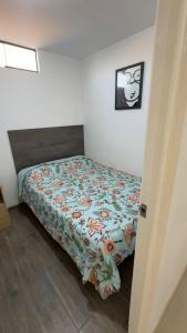 a bedroom with a bed with a floral comforter at Morada in Tacna
