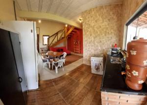 a kitchen and living room with a table and chairs at Chalé Jardim Mágico in Milho Verde