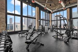a gym with treadmills and cardio equipment in a building with windows at 29th Floor Balcony Studio Miami Skyline Views in Miami