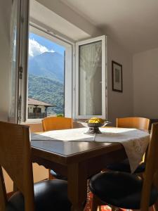 a dining room table with a view of a mountain at Casa Verde Valsassina 2 in Primaluna