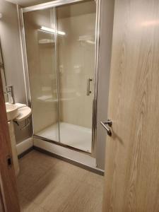 a shower in a bathroom with a glass door at Les Balcons du Sancy - Résidence de Tourisme in Picherande +7 photos