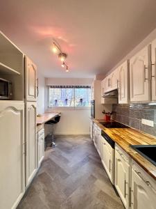 a kitchen with white cabinets and a table and a window at Cosy 4 pers in Chalon-sur-Saône