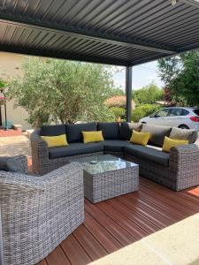 a patio with a couch and a table on a deck at Petit Luxe in Mortroux
