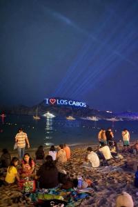a group of people sitting on a beach at night at Hotelcasacecinn in San José del Cabo