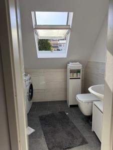 a bathroom with a toilet and a sink and a window at AdiFerienwohnung in Gerolstein