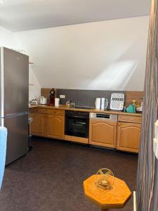 a kitchen with wooden cabinets and a stainless steel refrigerator at AdiFerienwohnung in Gerolstein