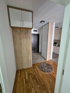 an empty living room with wooden floors and a kitchen at Garden Doboj in Doboj +9 photos