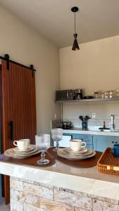 a kitchen with a table with two plates and glasses at Villa di Trevi Hospedagem em Pedra Azul in Domingos Martins