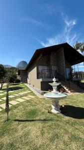 a white fountain in front of a house at Villa di Trevi Hospedagem em Pedra Azul in Domingos Martins