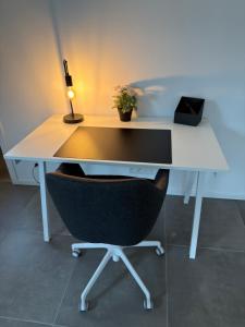 a white desk with a chair and a lamp at 't Wellement in Denderleeuw