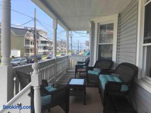 a porch with chairs and a table on a house at The Melrose in Ocean Grove