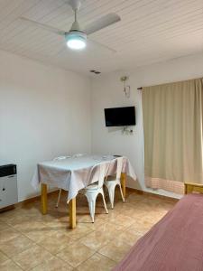 a dining room with a table and chairs and a tv at Departamentos MR in Villa Elisa