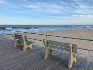 a wooden bench sitting on a boardwalk at the beach at The Melrose in Ocean Grove