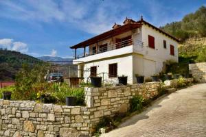 a house on a hill with a stone wall at Villa Romario in Berat
