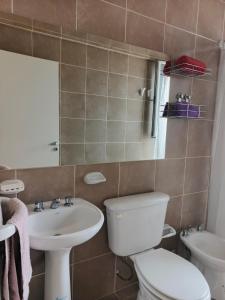a bathroom with a toilet and a sink at Depto tranquilo y equipado cerca del mar in Puerto Madryn