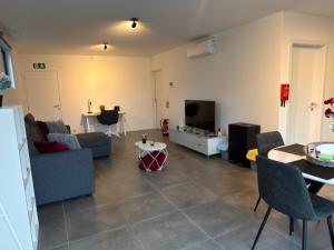 a living room with a couch and a tv at 't Wellement in Denderleeuw